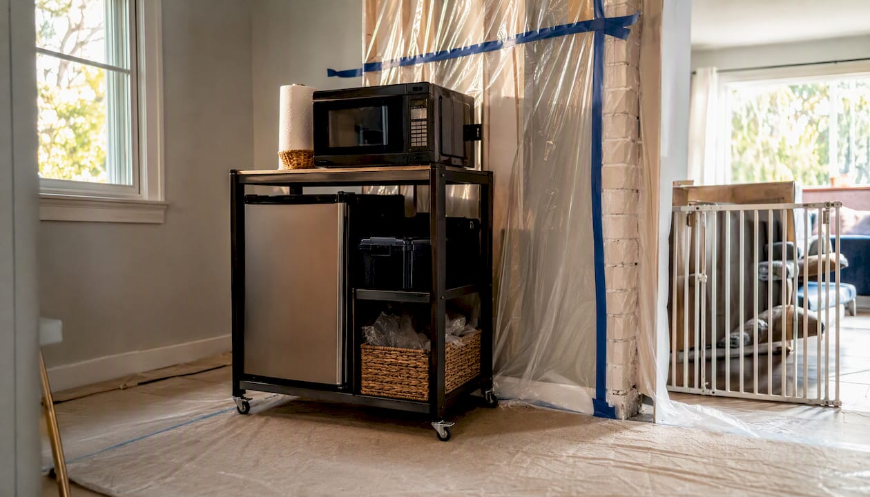 Temporary kitchen with rolling cart and plastic sheeting