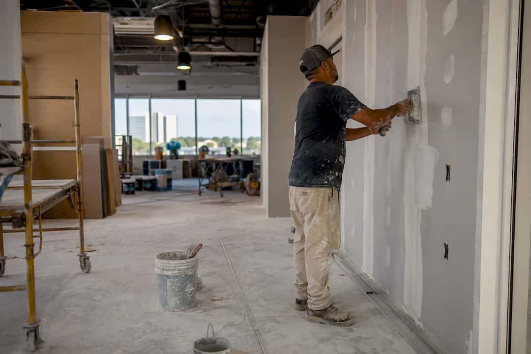 Worker applying drywall in an office renovation project in Florida.