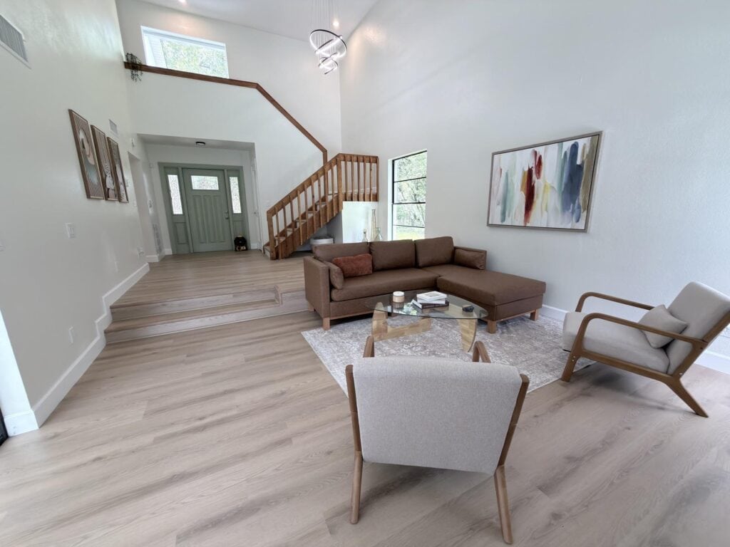 Flooring contractor Tampa Bay: warm oak plank floor through a finished, furnished living room