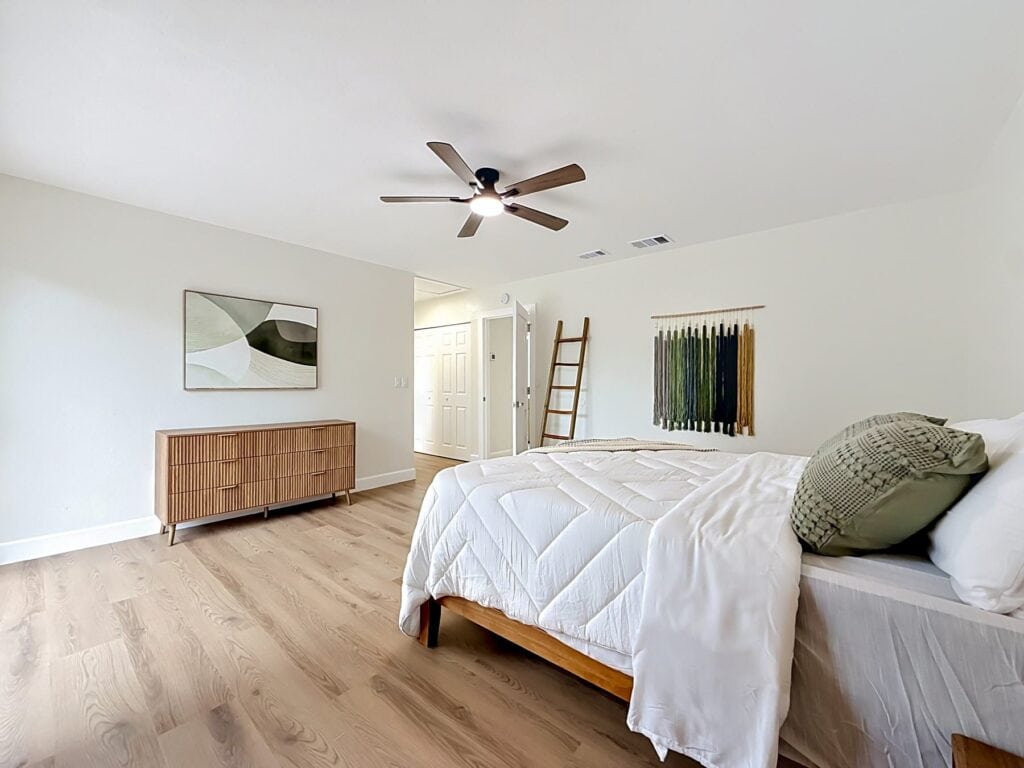 LVP flooring Tampa: light wood-look plank floor in a finished bedroom